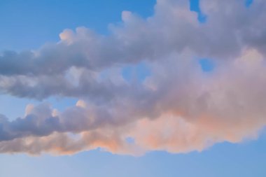 Fabrika bacasından beyaz duman, mavi günbatımına karşı baca.