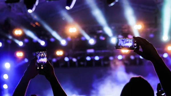 Man hands recording video of live music concert with smartphone