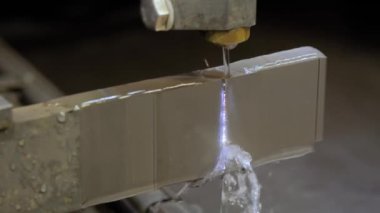 Fabrikada kıvılcımlarla çalışan tel kesme makinesi.