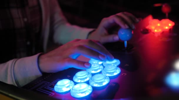 Женщина-геймер нажимает синие кнопки ретро-игрового автомата в темной комнате — стоковое видео