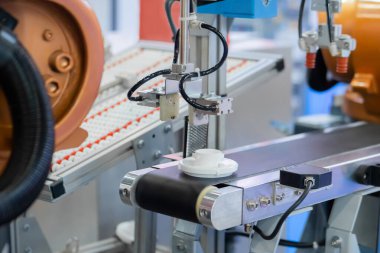 Taşıyıcı bant üzerinde plastik detayı hareket ettiren robotik kol manipülatörü seçin ve yerleştirin