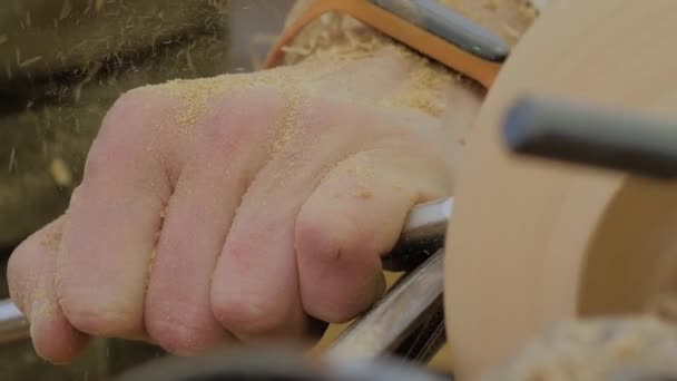 Carpenter holding chisel, shaping piece of wood on lathe: close up, slow motion — Stockvideo