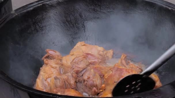 Chef cooking lamb meat for pilaf, pilau in huge cauldron - close up — Stock video
