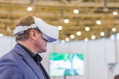 Sanal gerçeklik kulaklığı kullanan ve etkileşimli video sunumu izleyen adam