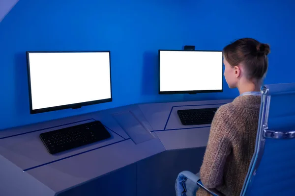 Woman looking at two monitors with white displays - mock up concept