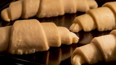 Timelapse - four homemade croissants baking and rising in oven at home: close up