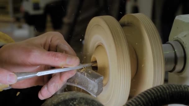 Carpenter using chisel for shaping piece of wood on lathe: close up, slow mo — Stockvideo