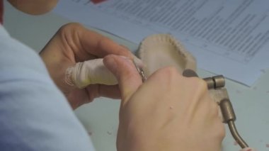 Diş teknisyeni diş tacıyla çalışıyor. Görüntüyü kapat.