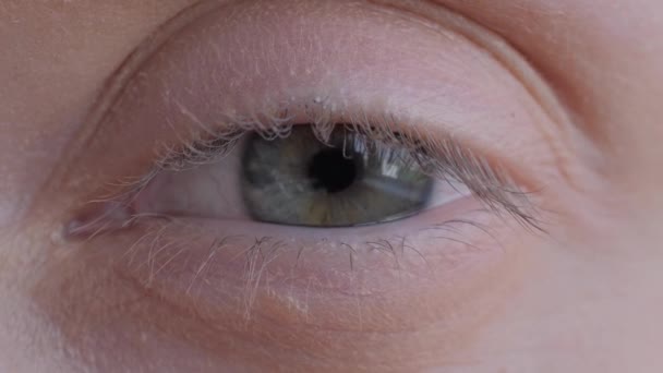 Woman opening and closing her eye, looking at camera - extreme close up, macro — Stock Video