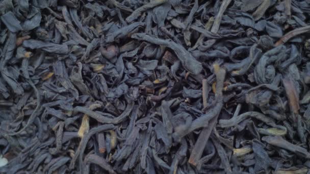 Horní pohled: hromada sušeného černého čaje na pomalu se otáčejícím povrchu - zblízka — Stock video