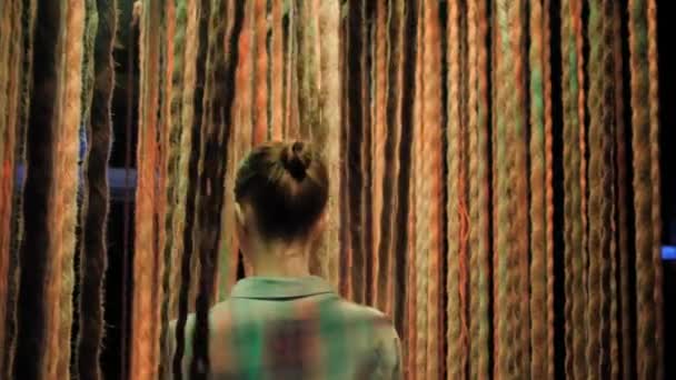 Žena procházející závěsné provazy s barevným osvětlením — Stock video
