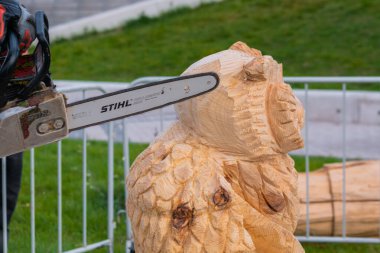 Yakın çekim: marangoz ahşap heykel oymak için testere kullanıyor