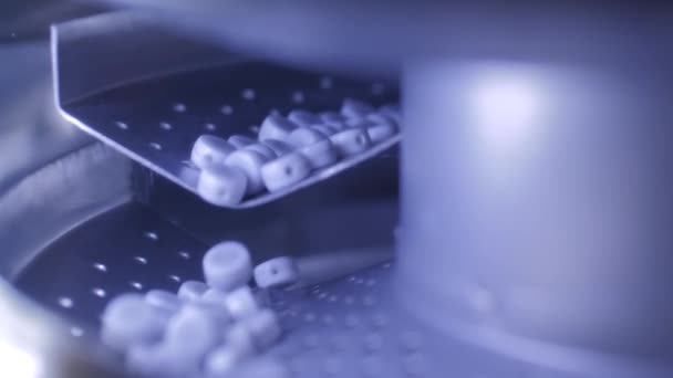 Nahaufnahme: Entstaubungsmaschine mit Förderband zum Entstauben von Pillen, Tabletten, Medikamenten — Stockvideo