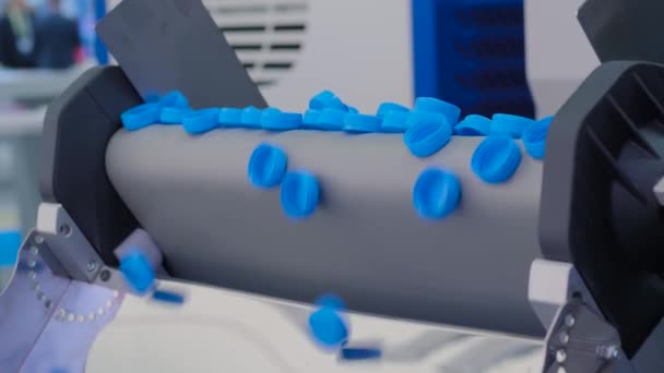 Veel blauwe plastic flessendoppen vallen van transportband - productielijn — Stockvideo