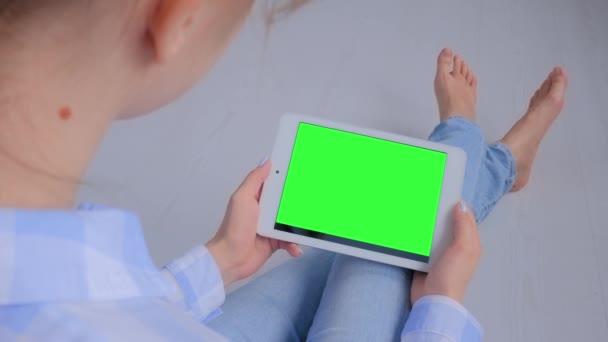 Green-Screen-Konzept - Frau blickt auf Tablet-Computer mit leerem grünen Bildschirm — Stockvideo