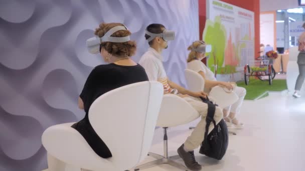 Ομάδα ανθρώπων που χρησιμοποιούν ακουστικά εικονικής πραγματικότητας στην έκθεση τεχνολογίας VR — Αρχείο Βίντεο