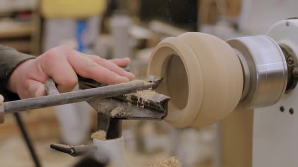 Carpintero usando cincel para dar forma a pieza de madera sobre torno con serrín: primer plano — Vídeo de stock
