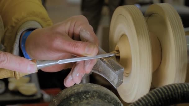 Langzame beweging: timmerman met behulp van beitel voor het vormen van stuk hout op draaibank: close-up — Stockvideo