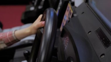 Eski oyun salonunda oyun direksiyonu kumandası kullanan kadın: Kapat