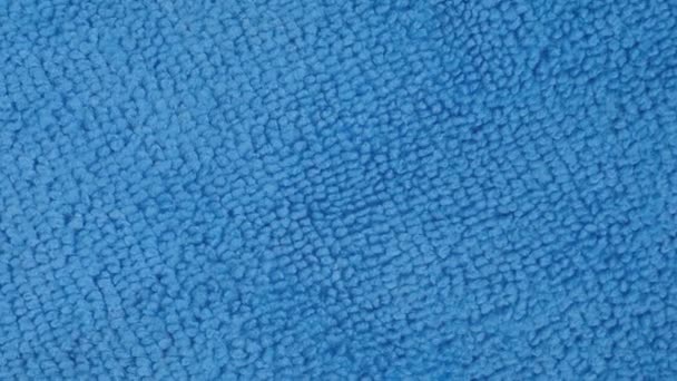 Visão superior: pano de limpeza de microfibra azul na superfície rotativa - close-up, macro — Vídeo de Stock