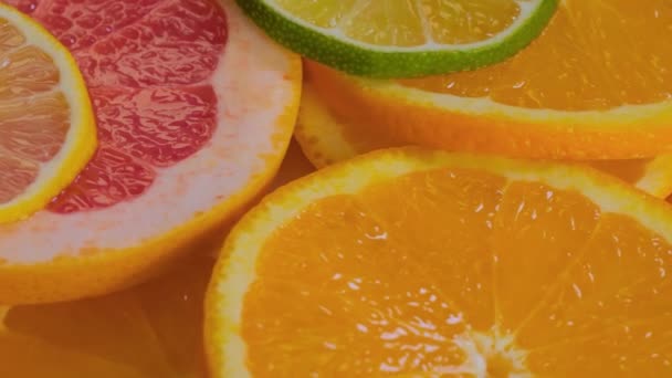 Fatias de citrinos - toranja, laranja, limão e limão na superfície rotativa — Vídeo de Stock