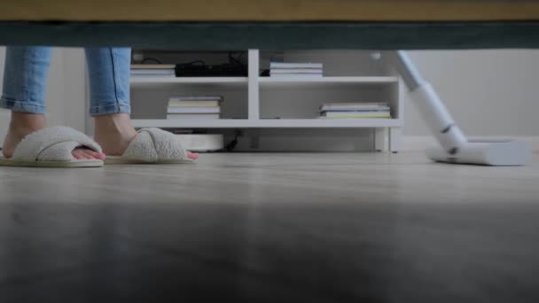 Vrouw schoonmaken woonkamer met witte moderne rechtop stofzuiger — Stockvideo