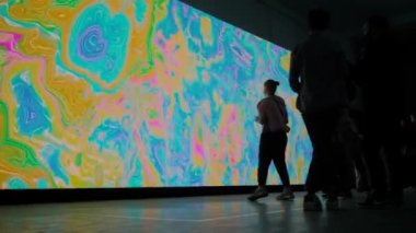 Geniş AR ekranının önünde ayna efektiyle hareket eden insanlar siluetleri