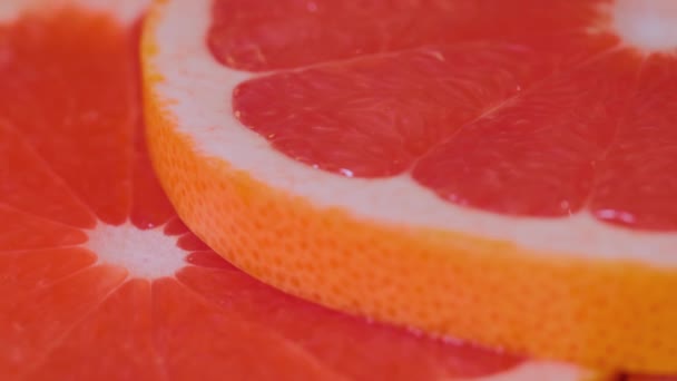 Frische Zitrusfrüchte, rote Scheiben Grapefruit auf rotierender Oberfläche - Nahaufnahme — Stockvideo