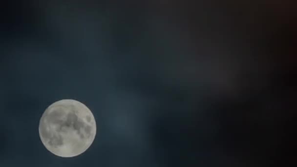 Время - восход луны на фоне черного неба с движущимися облаками ночью — стоковое видео