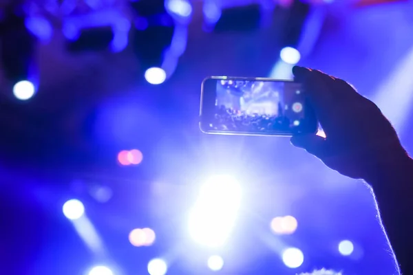 Man hands recording video of live music concert with smartphone