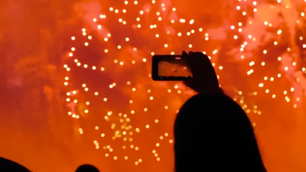Mujer grabación de vídeo de fuegos artificiales de colores en el cielo oscuro por la noche - cámara lenta — Vídeo de stock