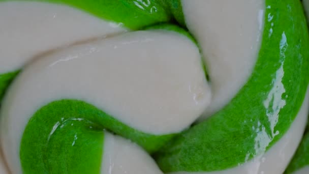Visão superior: verde e branco grande pirulito espiral doces girando - close-up — Vídeo de Stock