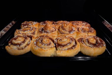 Evde elektrikli fırında 12 pişmiş tarçınlı çörek.