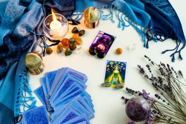 Minsk, Belarus - Şubat 2022: Tarot kehanetinde yıldız ve rahibe kartları, kurumuş çiçekler ve mavi bir masa örtüsü olan lambalar ve taşlar. Büyü ve okült