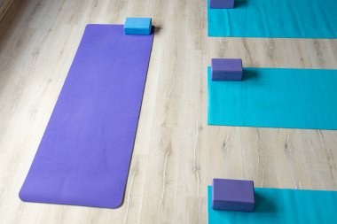 High angle view of exercise mats with blocks placed on hardwood floor in yoga studio