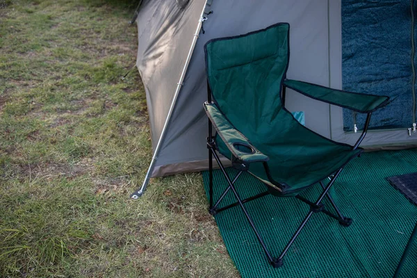 High angle of tent and chair against the background of grass at sunset