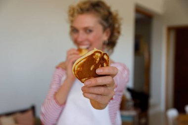 Kafkasyalı genç bir kadının portresi. Mutfakta gözleme tutarken kameraya gülüyor.