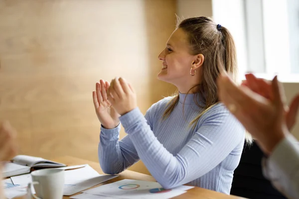 Team of professionals celebrating success, success concept with female leader and multiracial team in boardroom meeting