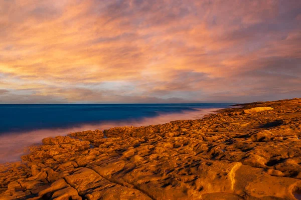 Sunset over the rocky coast in front of Praia da Luz in the Algarve in Portugal
