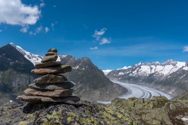 Bettmeralp yakınlarındaki cairn taşları ve arka planda Aletsch Buzul Dünya Mirası Alanı