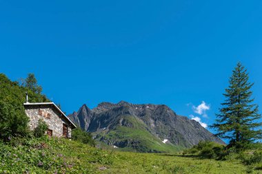 İsviçre, Valais 'teki Ulrichen yakınlarındaki Nufenen Geçidi' nin altındaki Ladstafel köyünün yakınındaki dağlık arazide dağ kulübesi.