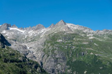 İsviçre 'de Valais Oberwald yakınlarındaki Furka Geçidi' nin yılanlarıyla Rhone Buzulu 'nun dağ kitlesi.