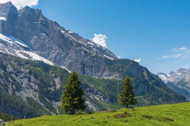 İsviçre 'nin Bernese Oberland kentindeki Kandersteg yakınlarında Oeschinen dağ istasyonu ve Oeschinensee gölü arasındaki manzara.