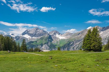 Oeschinen dağ istasyonu ile Oeschinsee arasındaki manzara soldaki Büyük Lohner tepeleri, sağdaki Küçük Lohner ve sağdaki ilk dağ İsviçre 'nin Bernese Oberland bölgesindeki Kandersteg' e yakın.