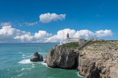 Portekiz 'deki Algarve' de Sagres yakınlarında Cabo de Sao Vicente 'de deniz feneri olan Rocky sahili.