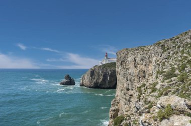Portekiz 'deki Algarve' de Sagres yakınlarında Cabo de Sao Vicente 'de deniz feneri olan Rocky sahili.