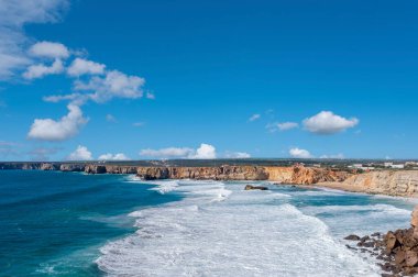 Portekiz 'deki Algarve' de Sagres yakınlarında Cabo de Sao Vicente 'de kayalıkların önünde dalgalar var.
