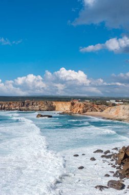 Portekiz 'deki Algarve' de Sagres yakınlarında Cabo de Sao Vicente 'de kayalıkların önünde dalgalar var.