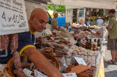 Cannobio, İtalya - 09 Ağustos 2018: İtalyan salam spesiyaliteleri ile haftalık Cannobio pazarında market tezgahı. Cannobio, İtalya 'nın Piedmont bölgesinde Maggiore Gölü' nde bir kasabadır.