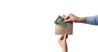 Beyaz arka planda 100 avroluk banknotlarla birlikte iş kadınının eli zarfı uzatıyor. Para aklama konsepti. AML. Bir yolsuzluk dolandırıcılığında iş adamına kahverengi zarfla rüşvet vermek.